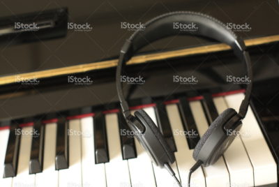 Headphones resting on a piano keyboard