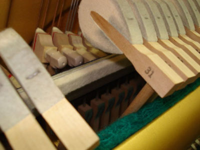 stop rail mechanism between hammers and strings on a silent piano