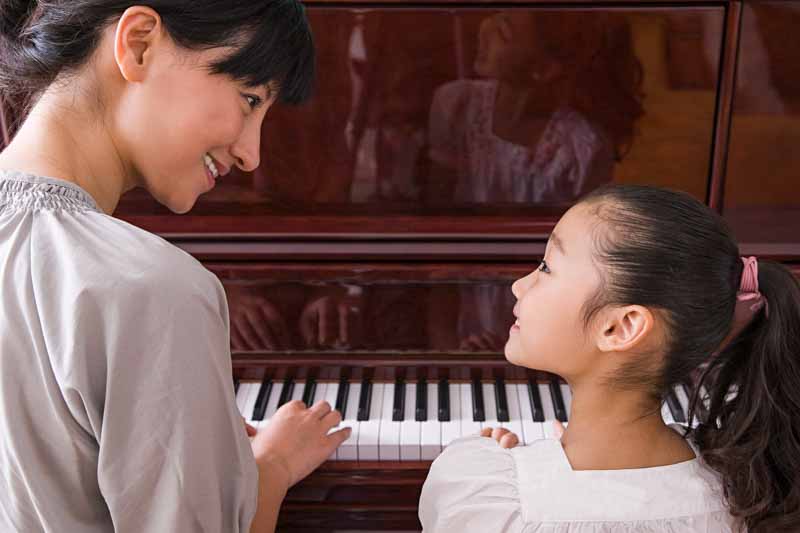 Piano teacher working with a beginning Piano player