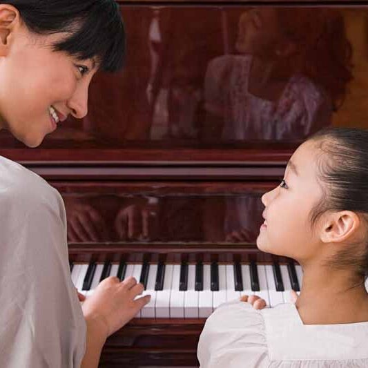 Piano teacher working with a beginning Piano player